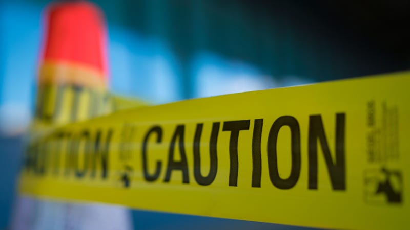 Yellow caution tape attached to traffic cone