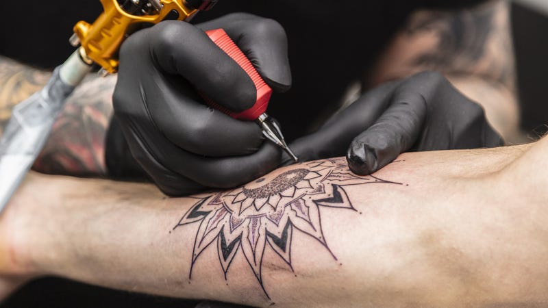 Process of creating tattoo in form of black flower