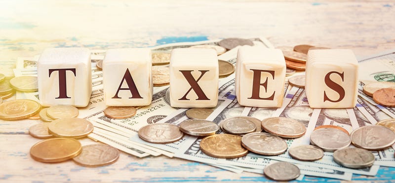 Word "TAXES" written with wooden cubes and money