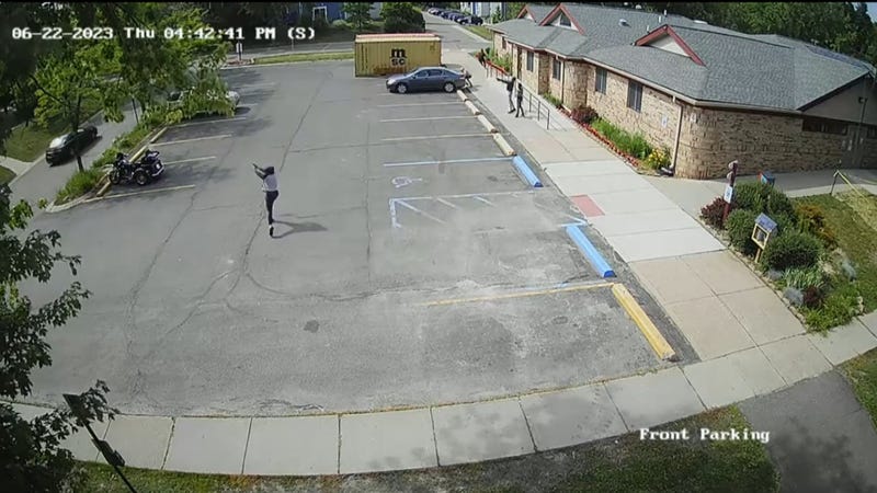Surveillance video from the scene of a shooting before a car was hit by gunfire and crashed into a tree
