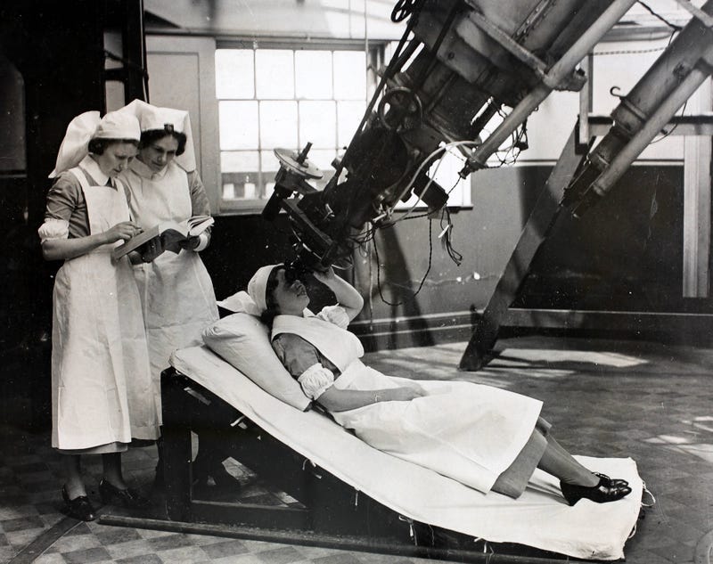 vintage picture of nurses looking through giant telescope