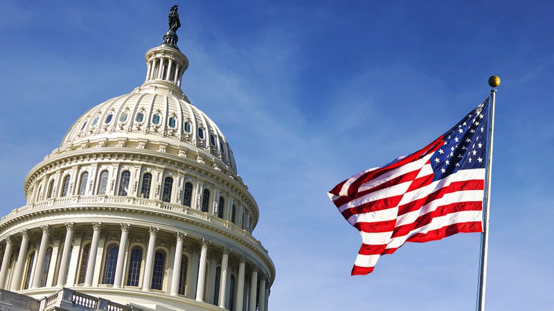 American flag waving with the Capitol Hill in the background