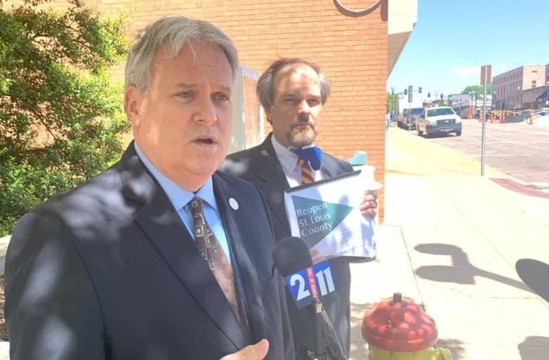 Tim Fitch stands outside speaking into a microphone