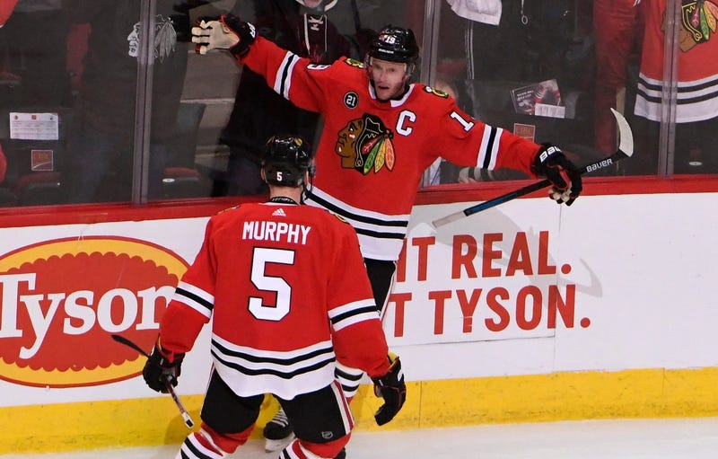 Blackhawks center Jonathan Toews (19) celebrates with defenseman Connor Murphy (5) after scoring the game-winning goal against the Canucks in overtime.