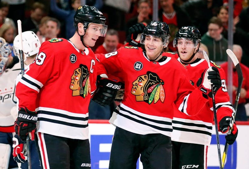 Blackhawks center Jonathan Toews (19) celebrates with teammate Patrick Kane (center) after scoring a goal.