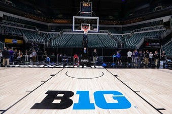 The seating area at Bankers Life Fieldhouse is empty as media and staff mill about, Thursday, March 12, 2020, in Indianapolis. (AP Photo/Michael Conroy)