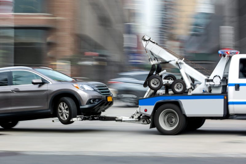 A tow truck hauls a car.