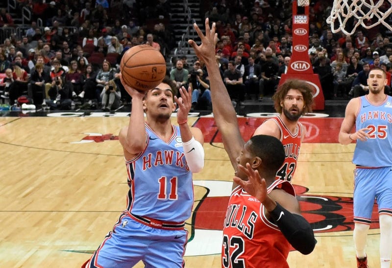 Hawks guard Trae Young (11) shoots over Bulls guard Kris Dunn (32).