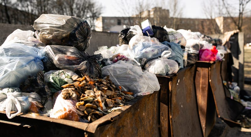 piles of trash in dumpsters