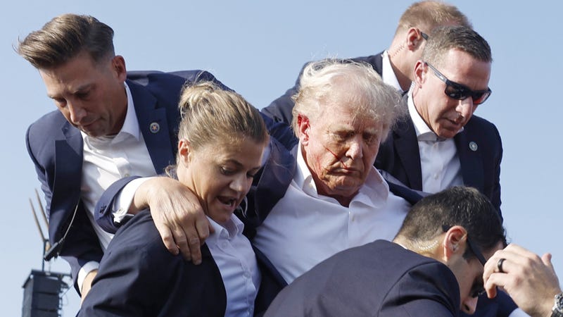 Republican presidential candidate former President Donald Trump is rushed offstage during a rally on July 13, 2024 in Butler, Pennsylvania. Butler County district attorney Richard Goldinger said the shooter is dead after injuring former U.S. President Donald Trump, killing one audience member and injuring another in the shooting.