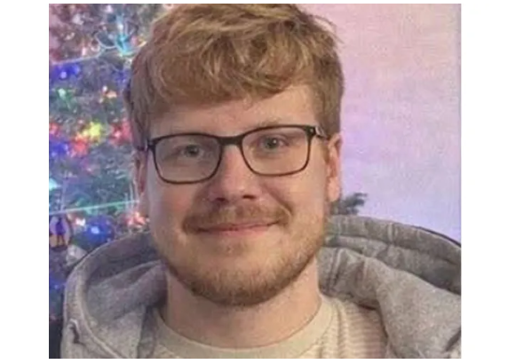 Smiling man with glasses by Christmas tree