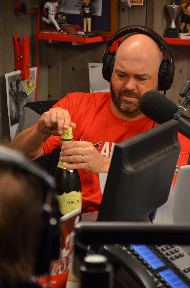 John 'Cakes' Auville has trouble popping some champagne to celebrate the Stanley Cup's arrival