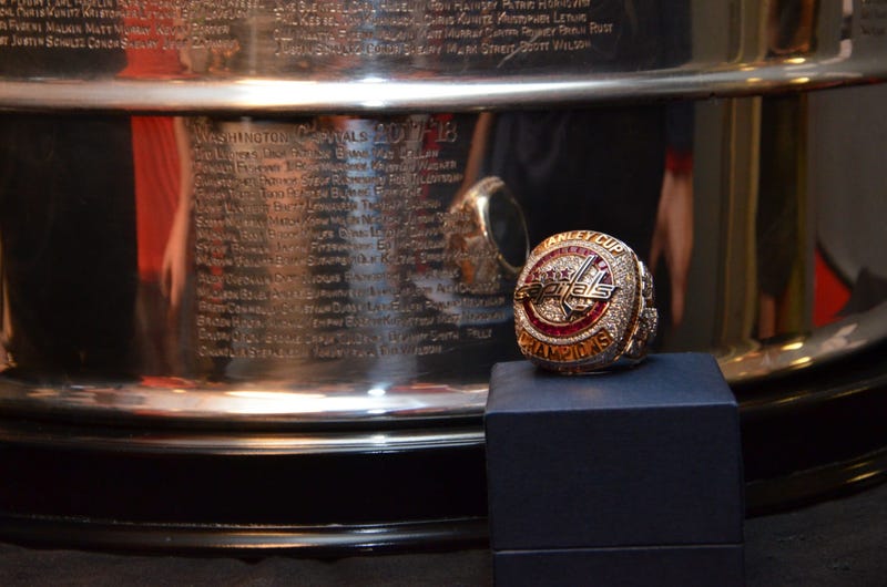 The Capitals' championship ring sits in front of a Stanley Cup backdrop