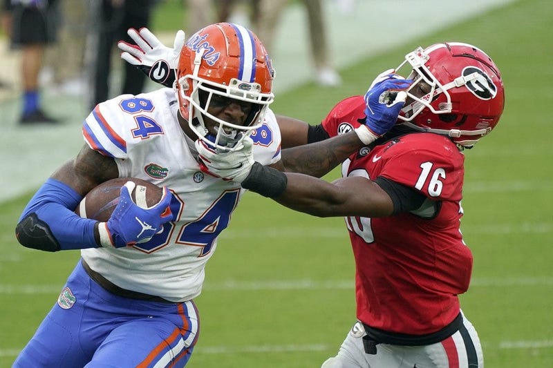 Florida tight end Kyle Pitts (84) tires to get past Georgia defensive back Lewis Cine (16) after a reception during the first half of an NCAA college football game, Saturday, Nov. 7, 2020, in Jacksonville, Fla. 