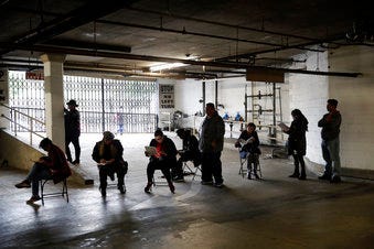 Unionized hospitality workers wait in line in a basement garage to apply for unemployment benefits at the Hospitality Training Academy Friday, March 13, 2020, in Los Angeles. (AP Photo/Marcio Jose Sanchez)