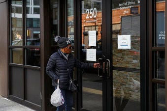 Visitors are unable to gain access to the Department of Labor due to closures over coronavirus concerns, Wednesday, March 18, 2020, in New York. (AP Photo/John Minchillo)