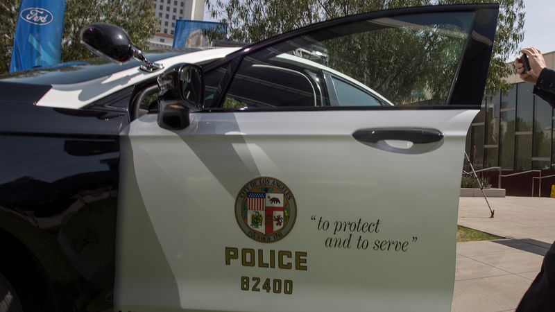 LOS ANGELES, CA - APRIL 10: An LAPD officer makes a smart phone video at the unveiling of two new Ford Fusion hybrid pursuit-rated Police Responder cars at Los Angeles Police Department headquarters on April 10, 2017 in Los Angeles, California. The LAPD is committed to purchasing at least 300 hybrid and hybrid-electric plug-in vehicles by 2020.