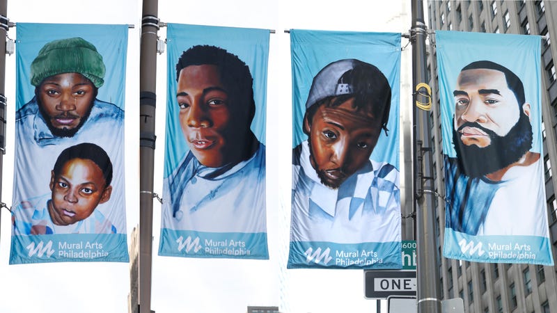 Banners featuring depictions of people whose lives were claimed by gun violence, painted by artist Russell Craig and hanging in Center City.