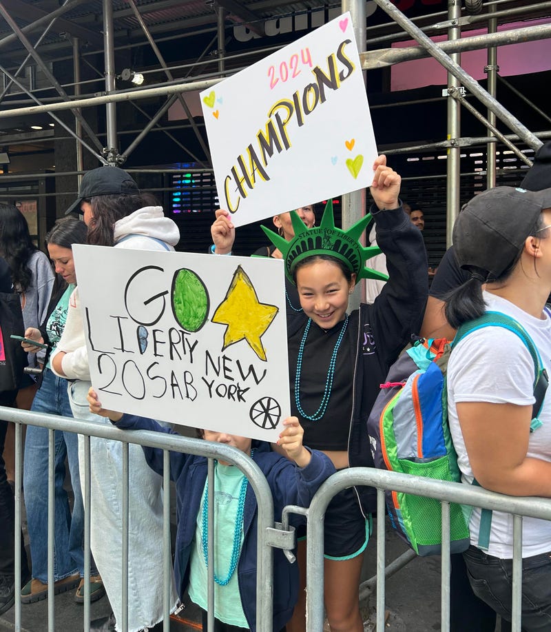 Fans hold up signs celebrating the Liberty title