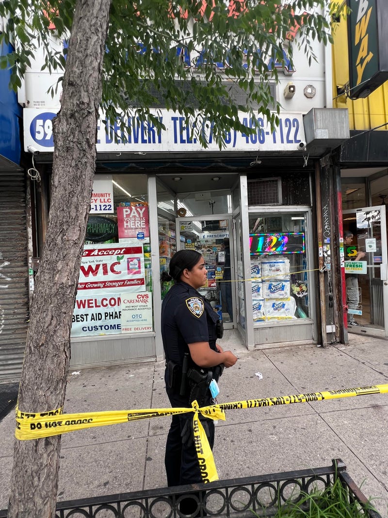Police stand outside Amazing Pharmacy in Tremont where a man was shot to death on Thursday.