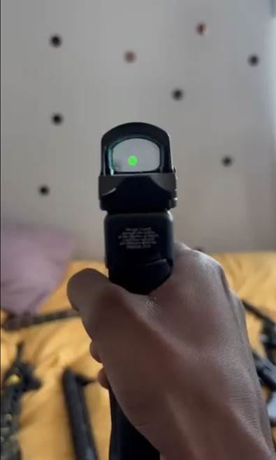 Photo of a pistol with a laser beam as part of the evidence provided in indictments charging over a dozen people in a series of East Harlem gang shootings.