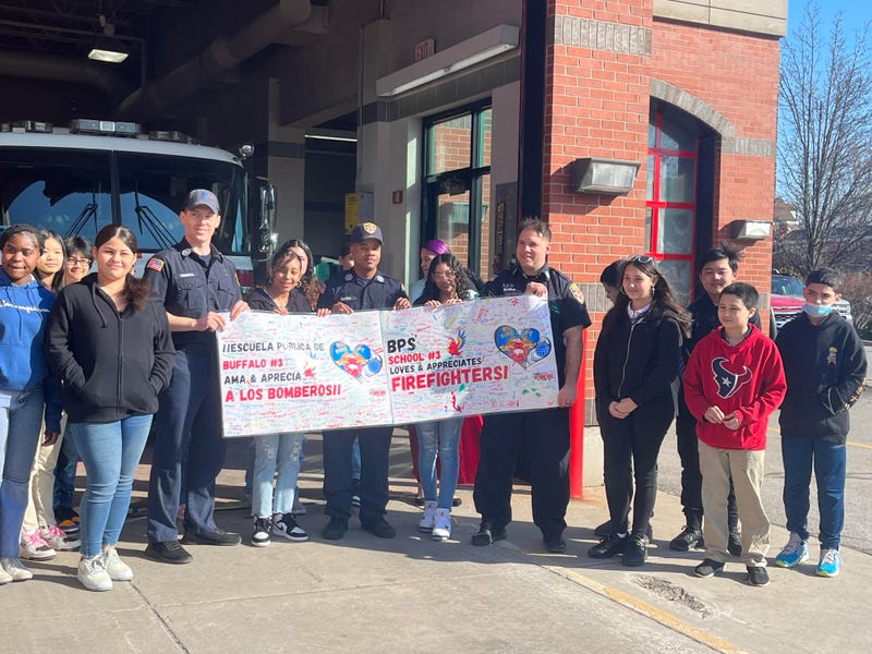 7th graders of Buffalo's School 3, the D'Youville Porter Campus School, standing with Buffalo firefighters of Engine No. 2.
