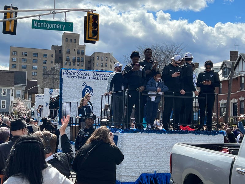 Members of the Saint Peter's Peacocks men's basketball team make their way down the parade route on JFK Boulevard on Friday afternoon.