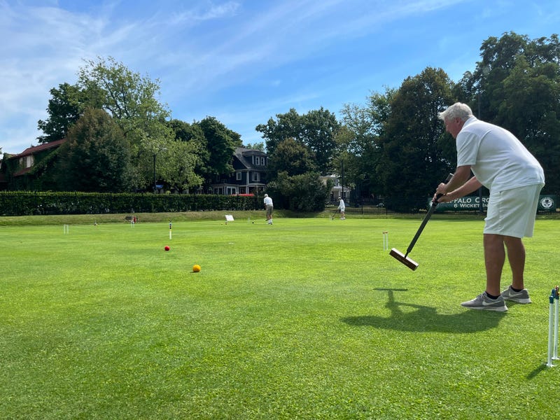 Gannon practices by taking a long whack at a far wicket in Delaware Park.