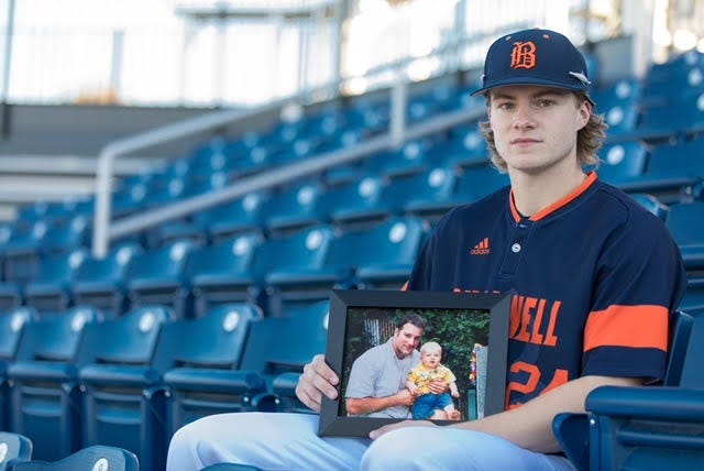 Chris Cannizzaro holding a photo of him and his dad, Brian, who died during the 9/11 attacks.