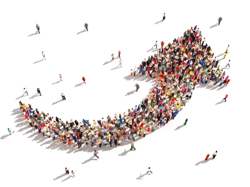 Large group of people in the shape of an arrow pointing up symbolizing direction , progress or growth