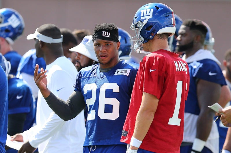 Saquon Barkley (26) chats with Eli Manning.