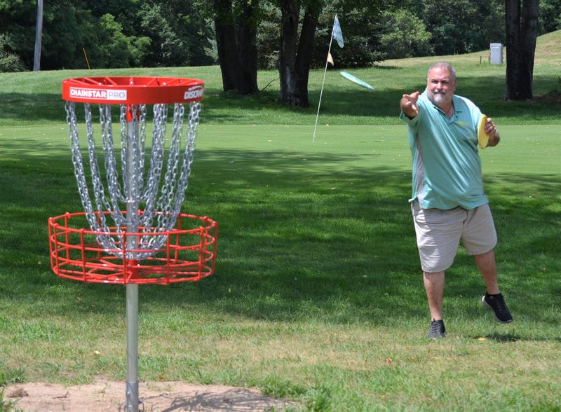 Course designer Jeff Carter makes a throw at the new Springbrook Disc G1.JPGolf Course, which opened earlier this month. springbrook disc golf 1.JPG