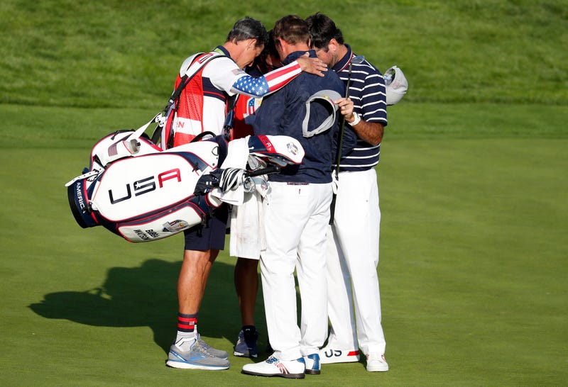 United States golfer Webb Simpson and United States golfer Bubba Watson huddle