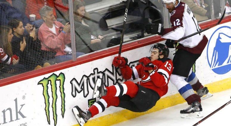 Nico Hischier goes down after a check by Patrik Nemeth during the third period at Prudential Center.