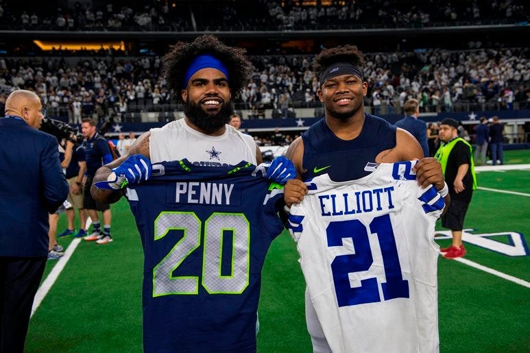 Jan 5, 2019; Arlington, TX, USA; Dallas Cowboys running back Ezekiel Elliott (left) exchanges jerseys with Seattle Seahawks running back Rashaad Penny (right) after a NFC Wild Card playoff football game at AT&T Stadium