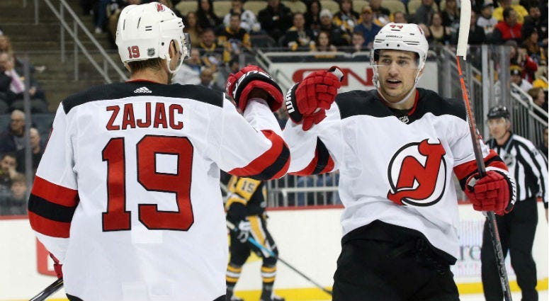 Travis Zajac celebrates after scoring a goal with Miles Wood against the Pittsburgh Penguins during the first period at PPG PAINTS Arena