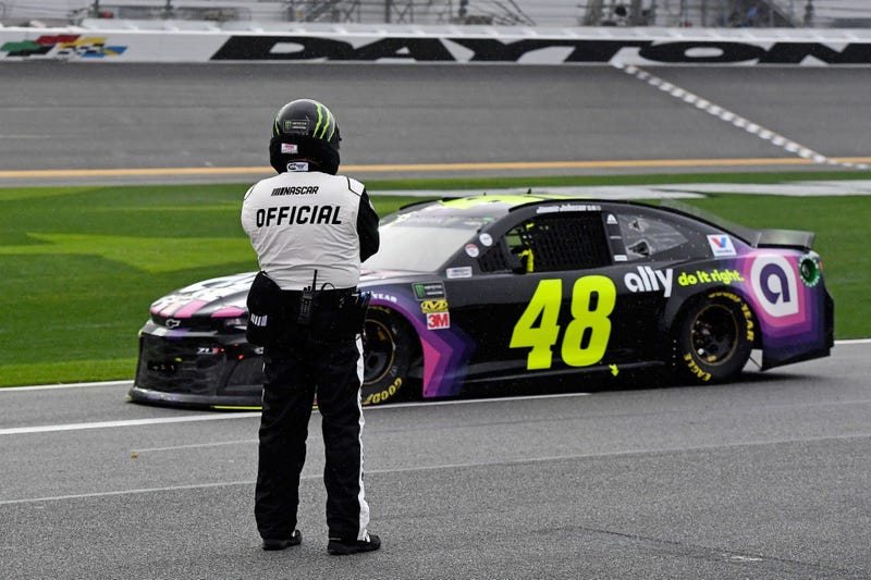 Feb 10, 2019; Daytona Beach, FL, USA; NASCAR Cup Series driver Jimmie Johnson (48) passes by a NASCAR official as the race is red flagged for rain during the Advance Auto Parts Clash at Daytona International Speedway.