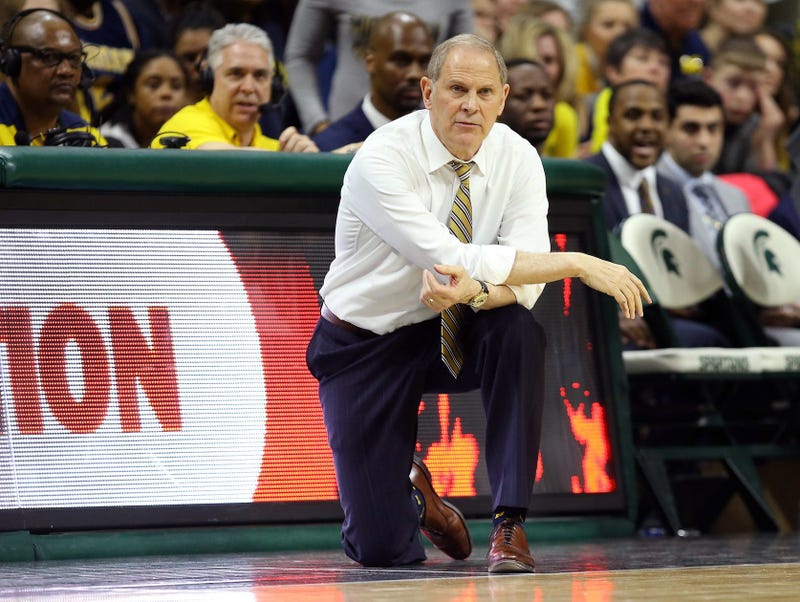 Michigan Wolverines head coach John Beilein knees on the court during the second half of a game against the Michigan State Spartans at the Breslin Center.