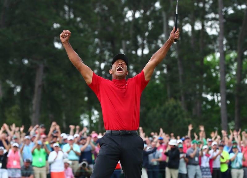 Tiger Woods celebrates after making a putt on the 18th green to win The Masters golf tournament at Augusta National Golf Club.