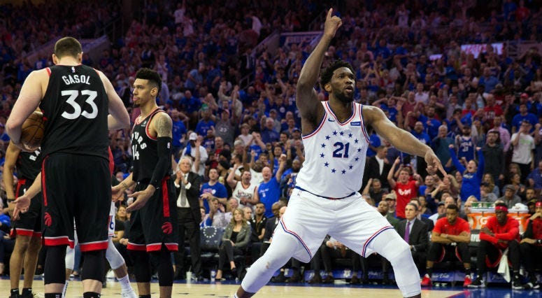 May 2, 2019; Philadelphia, PA, USA; Philadelphia 76ers center Joel Embiid (21) reacts in front of Toronto Raptors center Marc Gasol (33) and guard Danny Green (14) after a score in game three of the second round of the 2019 NBA Playoffs at Wells Fargo Cen