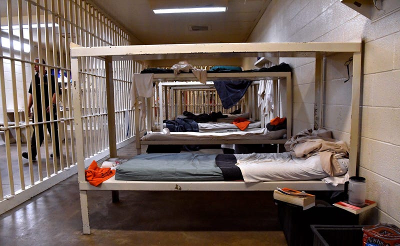 A guard performs a walk-through of a group cell at the Taylor County Jail while the prisoners stand in line to receive lunch June 21, 2019. 0707jail2