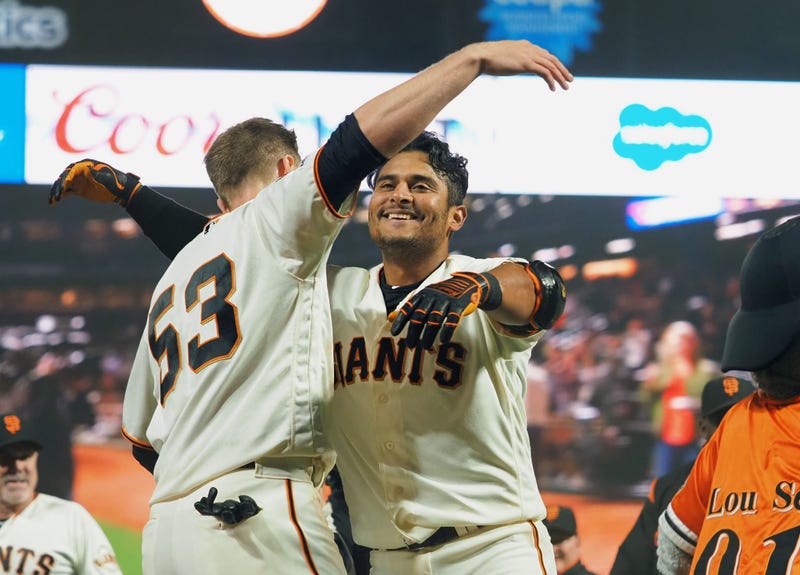 San Francisco Giants second baseman Donovan Solano (7) hugs right fielder Austin Slater (53) after hitting a walk-off single against the New York Mets during the sixteenth inning at Oracle Park on July 18, 2019. 