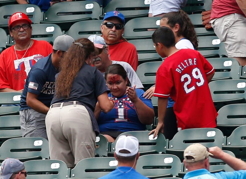 Rangers fans is attended to after being hit in the head with a ball