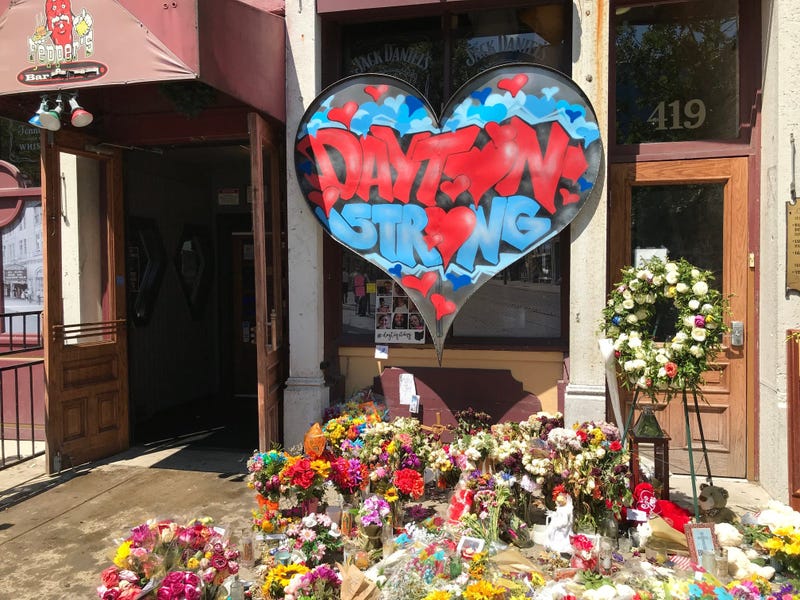 A memorial of flowers, cards, dolls and a Dayton Strong heart surround Ned Peppers outside the Aug. 4 mass shooting scene. Mass shooting memorial outside Ned Peppers