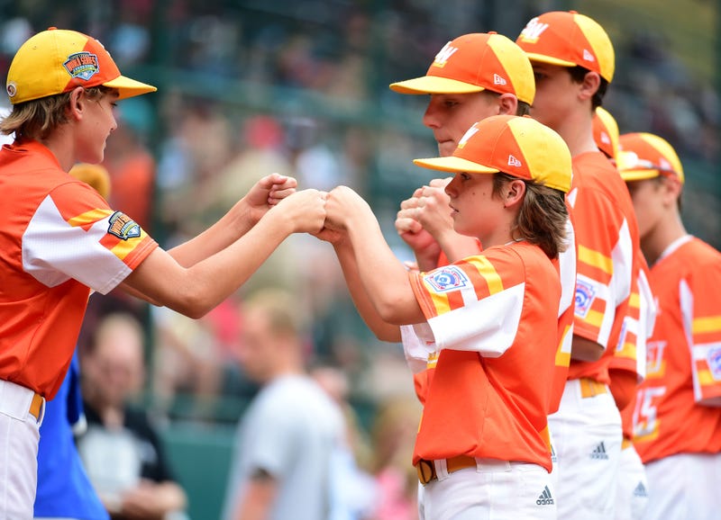 Southwest Region second baseman Derek DeLatte (7) high fives teammates prior to the game against the Caribbean Region during the Little League World Series at Howard J. Lamade Stadium.