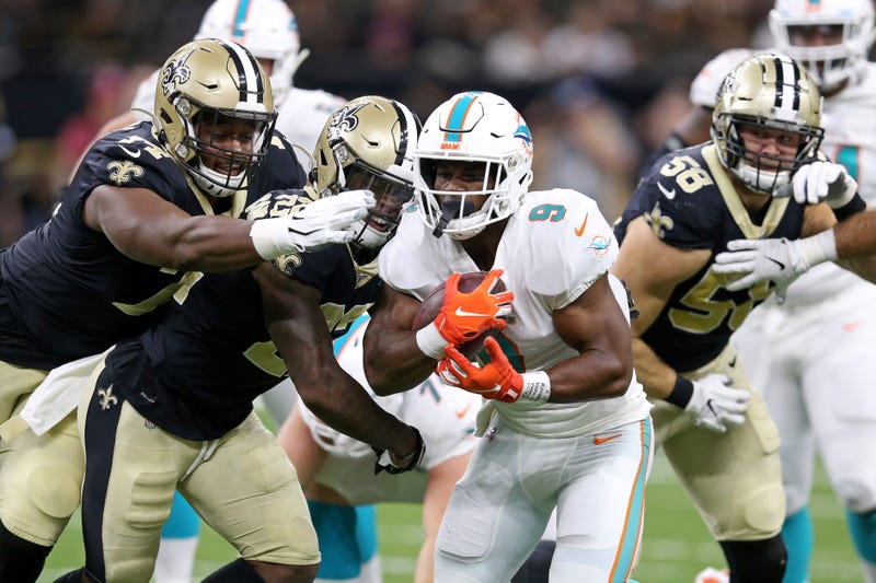 Miami Dolphins running back Mark Walton (9) is chased by New Orleans Saints defensive tackle Shy Tuttle (74) and defensive back Chauncey Gardner-Johnson (22) in the first quarter at the Mercedes-Benz Superdome.