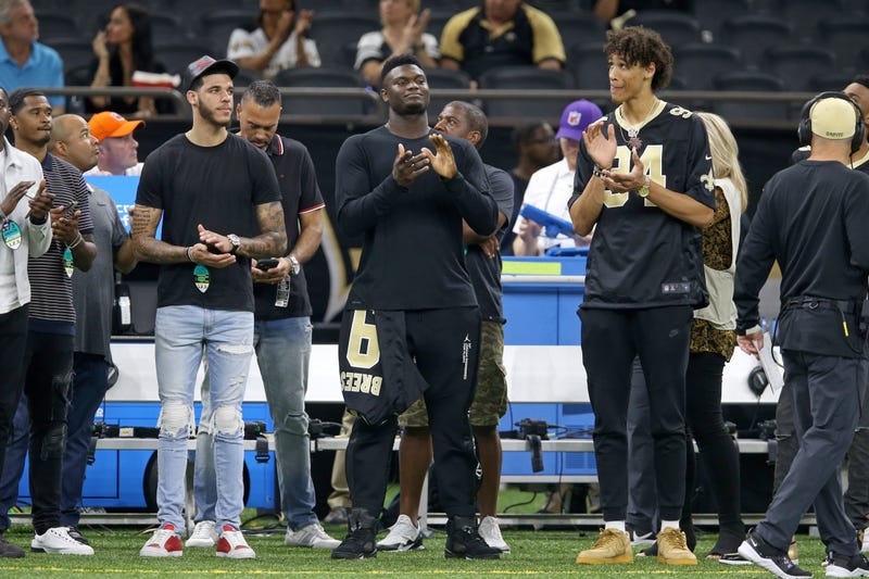 New Orleans Pelicans players Lonzo Ball (left) and Zion Williamson (center) and Jaxson Hayes (right) look on from the sidelines before the game between the New Orleans Saints and the Houston Texans at the Mercedes-Benz Superdome.