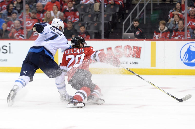 Oct 4, 2019; Newark, NJ, USA; New Jersey Devils center Blake Coleman (20) scores a goal while being checked by Winnipeg Jets defenseman Dmitry Kulikov (7) during the second period at Prudential Center.