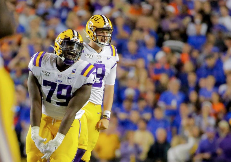 LSU Tigers quarterback Joe Burrow (9) and center Lloyd Cushenberry III (79) celebrate after a touchdown against the Florida Gators during the fourth quarter at Tiger Stadium.