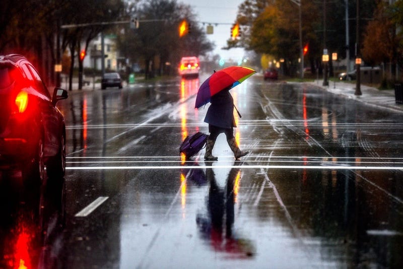 A pedestrian carries a colorful umbrella 